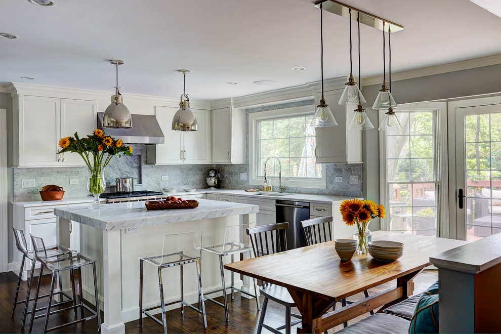 Mid-sized transitional u-shaped eat-in kitchen in Chicago with shaker cabinets, white cabinets, marble benchtops, with island, a single-bowl sink, white splashback, porcelain splashback, stainless steel appliances and medium hardwood floors.