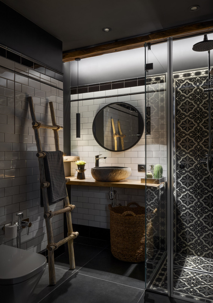 Design ideas for a small industrial powder room in Moscow with a wall-mount toilet, white tile, ceramic tile, white walls, porcelain floors, a drop-in sink, wood benchtops, black floor and beige benchtops.
