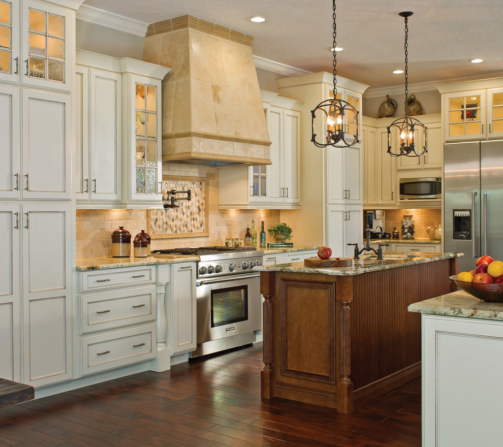 This is an example of a traditional u-shaped kitchen in Nashville with shaker cabinets, white cabinets, beige splashback, stainless steel appliances, with island and travertine splashback.