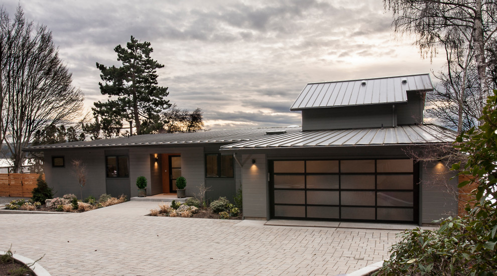 Großes, Zweistöckiges Modernes Haus mit grauer Fassadenfarbe, Blechdach, Pultdach, braunem Dach und Wandpaneelen in Seattle