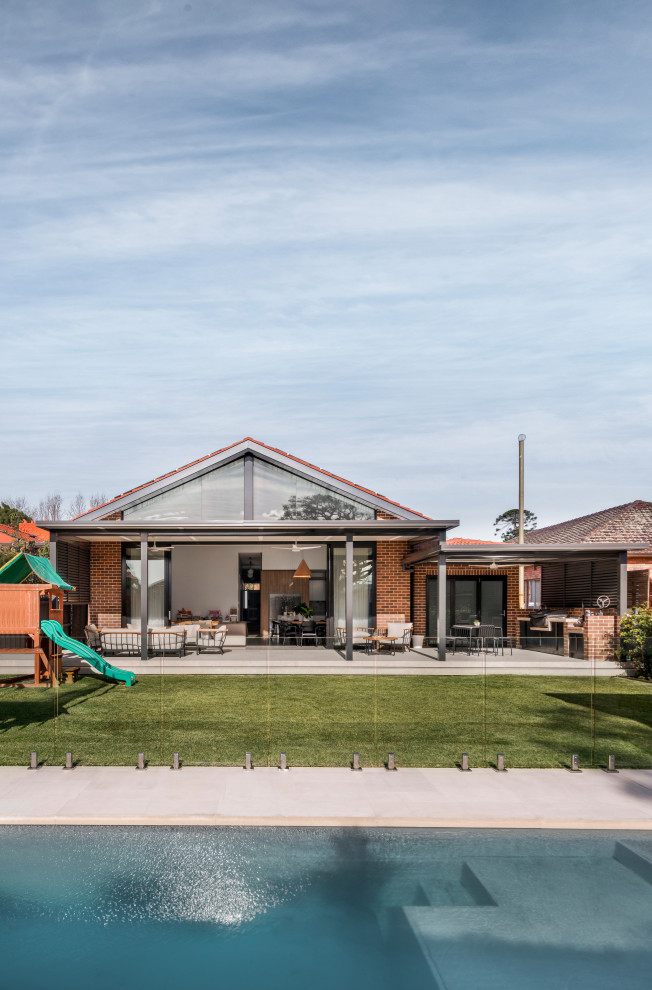 Inspiration for a mid-sized contemporary one-storey brick beige house exterior in Sydney with a hip roof and a tile roof.