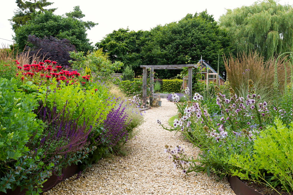 Large country backyard garden in Oxfordshire with a garden path and gravel for summer.