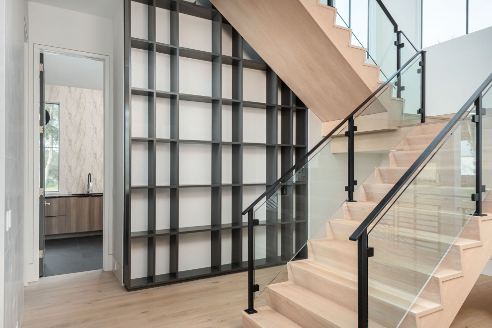 This is an example of a large modern wood l-shaped staircase in Charleston with wood risers, metal railing and wood walls.