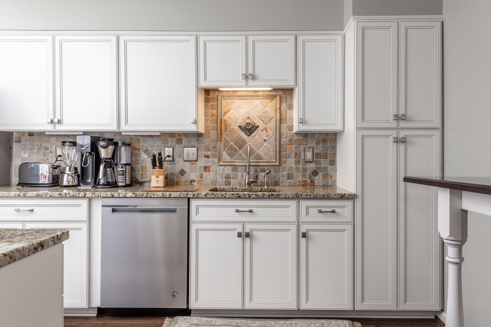 Photo of a mid-sized transitional galley kitchen pantry in Baltimore with an undermount sink, recessed-panel cabinets, white cabinets, granite benchtops, multi-coloured splashback, cement tile splashback, stainless steel appliances, medium hardwood floors, no island, brown floor and multi-coloured benchtop.