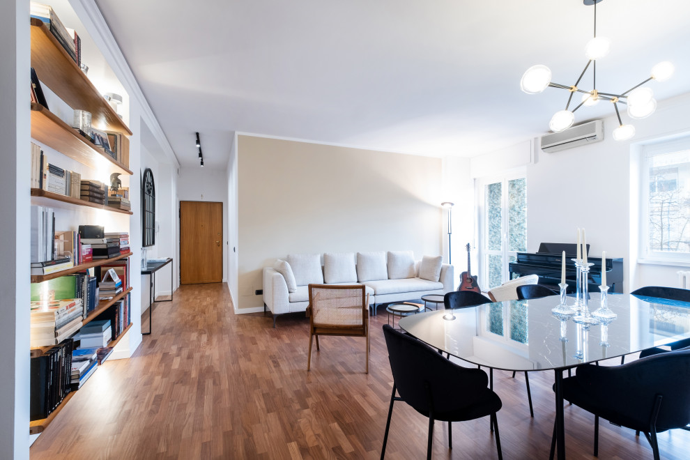 Immagine di un soggiorno mediterraneo di medie dimensioni e aperto con libreria, pareti bianche, parquet scuro, nessuna TV e con abbinamento di divani diversi