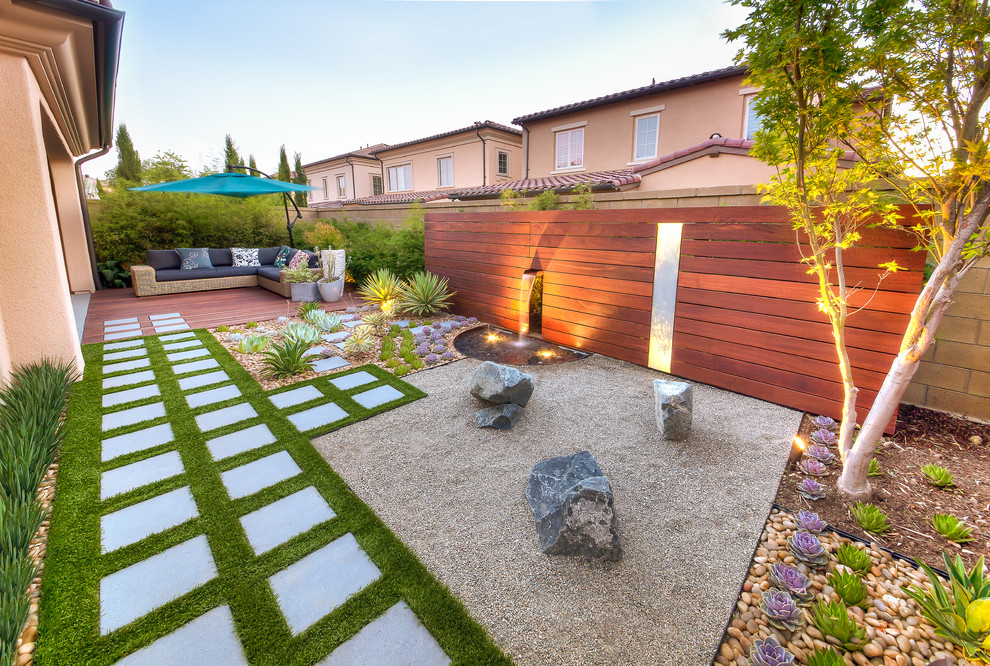 This is an example of a mid-sized modern backyard patio in Orange County with concrete pavers.