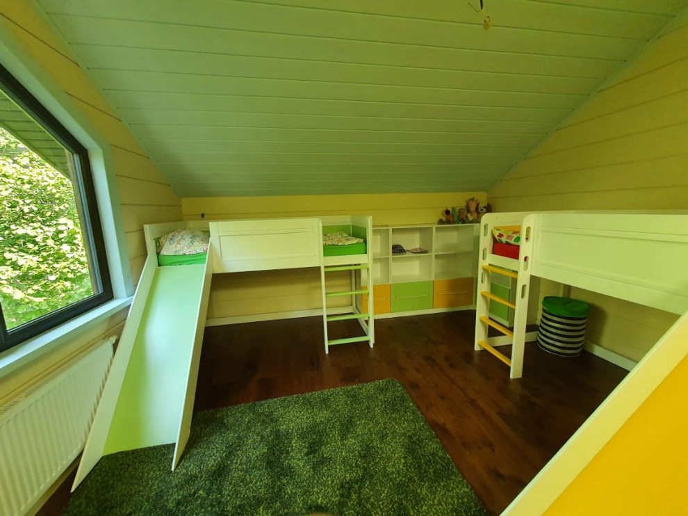 Modelo de dormitorio infantil de 4 a 10 años escandinavo grande con paredes amarillas, suelo de madera oscura, suelo marrón, madera y machihembrado