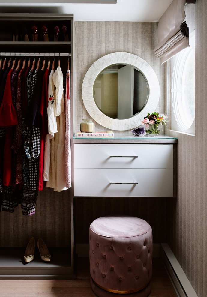 Diseño de vestidor de mujer minimalista de tamaño medio con armarios con paneles lisos, puertas de armario blancas y suelo de madera en tonos medios