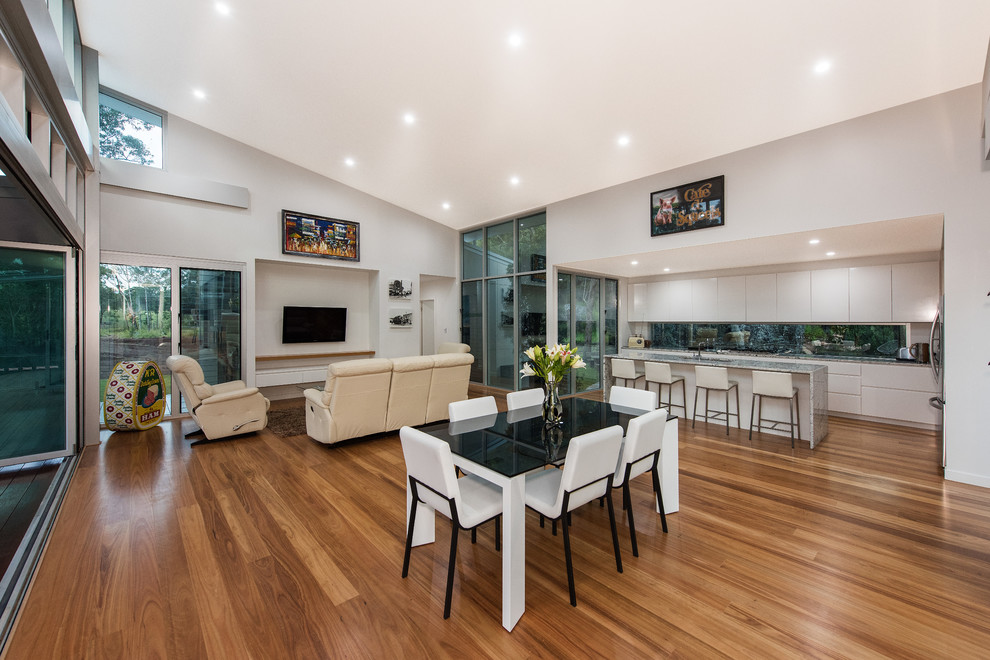 Transitional dining room in Brisbane with medium hardwood floors.