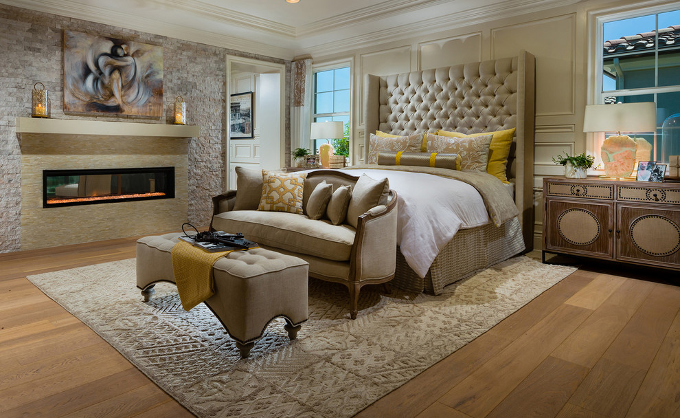 Design ideas for a large mediterranean master bedroom in San Diego with beige walls, light hardwood floors, a ribbon fireplace and a tile fireplace surround.