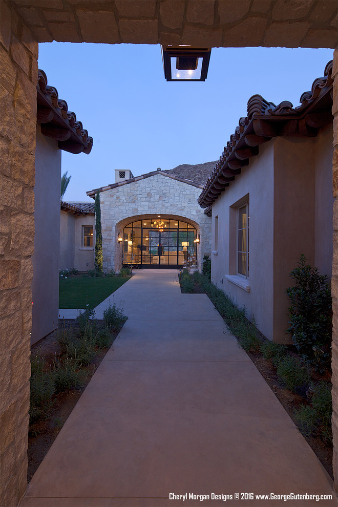 Inspiration for a large country one-storey stucco beige exterior in Los Angeles with a gable roof.