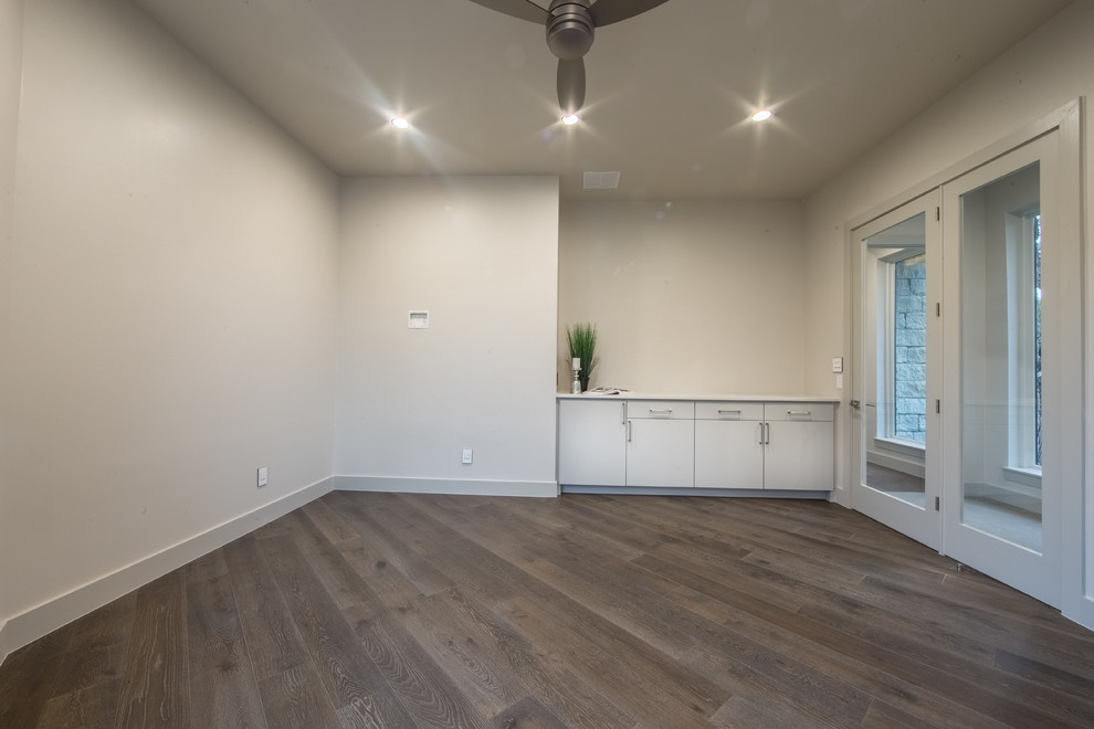 Photo of a mid-sized contemporary home office in Austin with white walls and medium hardwood floors.