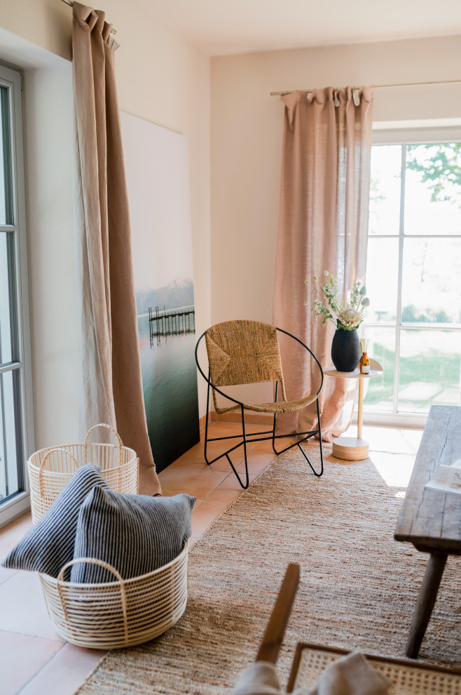 Foto de sala de estar abierta mediterránea de tamaño medio con paredes beige, suelo de baldosas de terracota, estufa de leña y suelo naranja