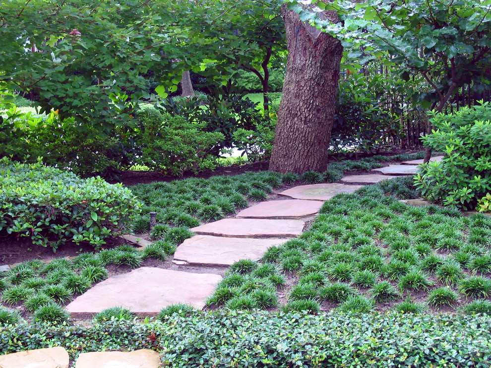 Mediterranean backyard garden in Houston with natural stone pavers.