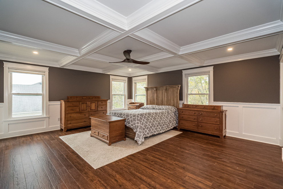 Großes Klassisches Hauptschlafzimmer ohne Kamin mit brauner Wandfarbe, braunem Holzboden, braunem Boden, Kassettendecke und vertäfelten Wänden in St. Louis