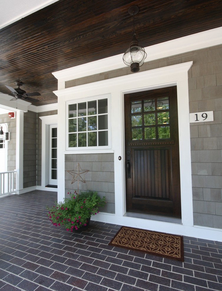 This is an example of a beach style front door in Chicago with a single front door and a dark wood front door.