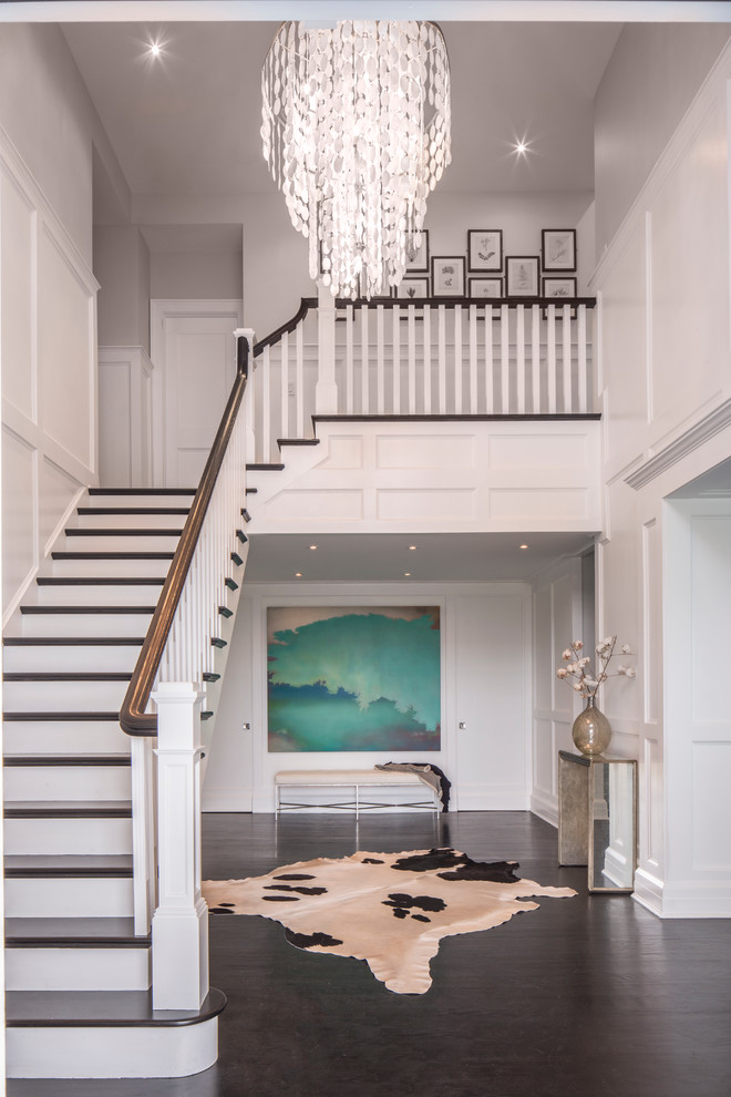 This is an example of an expansive beach style foyer in New York with white walls, dark hardwood floors, a single front door and a black front door.