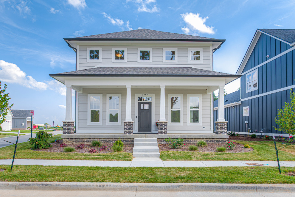 Mittelgroßes, Zweistöckiges Rustikales Einfamilienhaus mit Vinylfassade, beiger Fassadenfarbe, Schindeldach, grauem Dach und Verschalung in Indianapolis