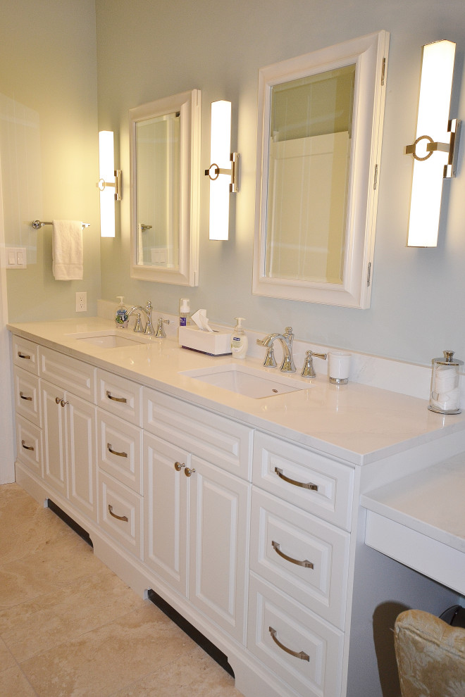 This is an example of a mid-sized transitional master bathroom in Other with raised-panel cabinets, white cabinets, a curbless shower, a two-piece toilet, beige tile, travertine, blue walls, travertine floors, a drop-in sink, engineered quartz benchtops, beige floor, a hinged shower door, white benchtops, a niche, a double vanity and a freestanding vanity.