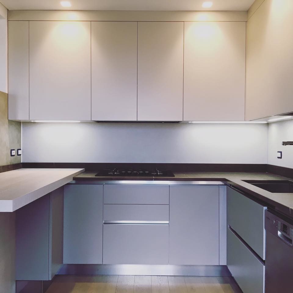 Photo of a mid-sized modern u-shaped eat-in kitchen in Other with an undermount sink, flat-panel cabinets, grey cabinets, limestone benchtops, brown splashback, limestone splashback, stainless steel appliances, painted wood floors, no island, brown floor and brown benchtop.