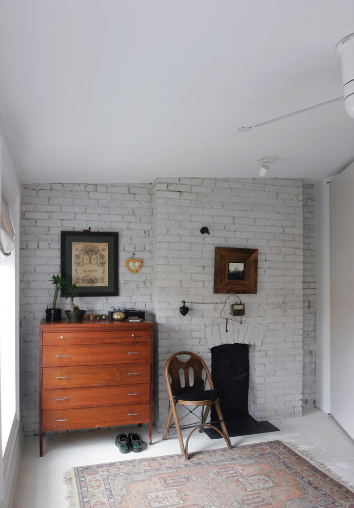 Idées déco pour une petite chambre parentale contemporaine avec un mur blanc, parquet peint, une cheminée standard, un manteau de cheminée en brique et un sol blanc.