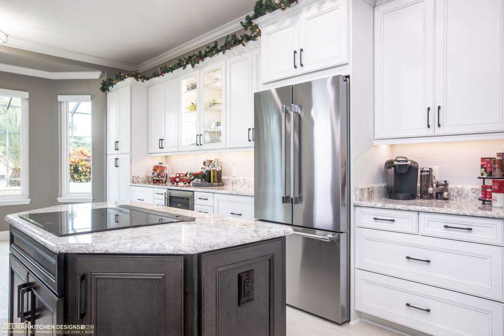Large transitional l-shaped kitchen pantry in Orlando with an undermount sink, raised-panel cabinets, white cabinets, quartz benchtops, white splashback, ceramic splashback, porcelain floors, with island and multi-coloured benchtop.