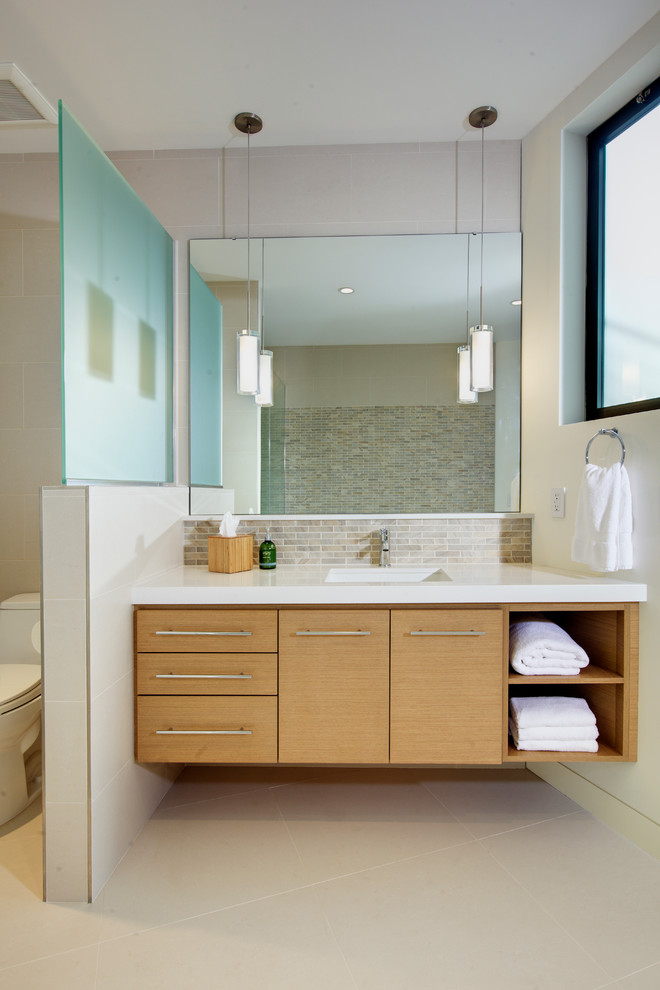 Design ideas for a contemporary bathroom in Los Angeles with an undermount sink, flat-panel cabinets, light wood cabinets and beige tile.