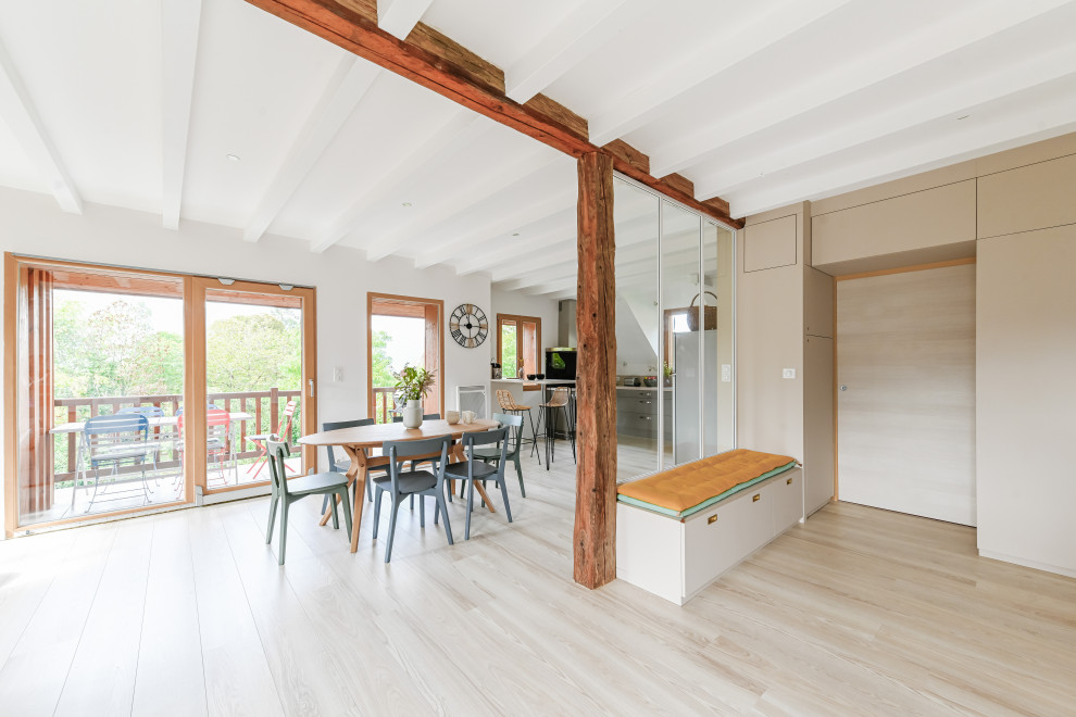 This is an example of a mid-sized scandinavian open concept family room in Lyon with a library, white walls, light hardwood floors and exposed beam.