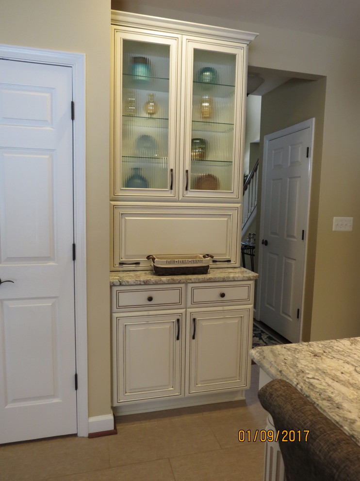 Mid-sized transitional l-shaped ceramic tile eat-in kitchen photo with an undermount sink, raised-panel cabinets, distressed cabinets, granite countertops, white backsplash, porcelain backsplash, stainless steel appliances and an island