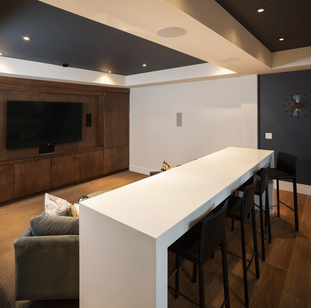 Photo of an expansive contemporary open concept home theatre in Calgary with white walls, carpet and a wall-mounted tv.
