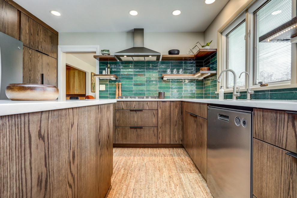 This is an example of a large retro u-shaped kitchen/diner in Other with a submerged sink, flat-panel cabinets, dark wood cabinets, engineered stone countertops, green splashback, ceramic splashback, stainless steel appliances, cork flooring, an island, brown floors and white worktops.