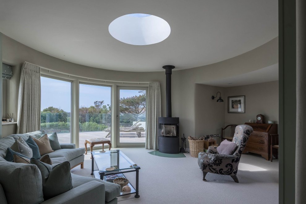 Großes Modernes Wohnzimmer mit beiger Wandfarbe, Teppichboden, Kaminofen und beigem Boden in Cornwall
