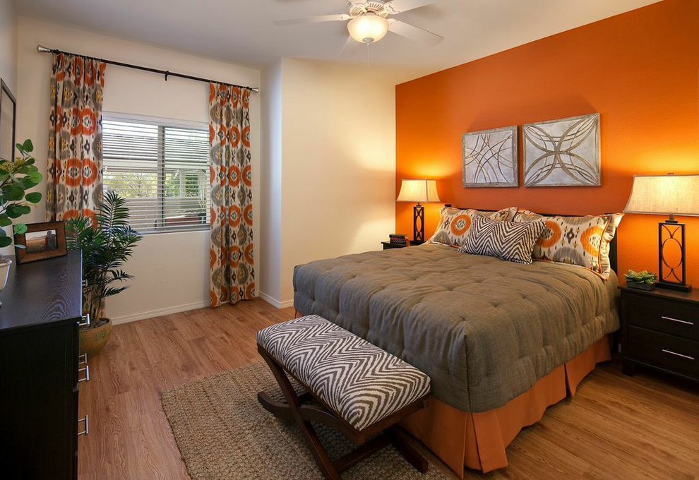 Small transitional master bedroom in Santa Barbara with orange walls and bamboo floors.