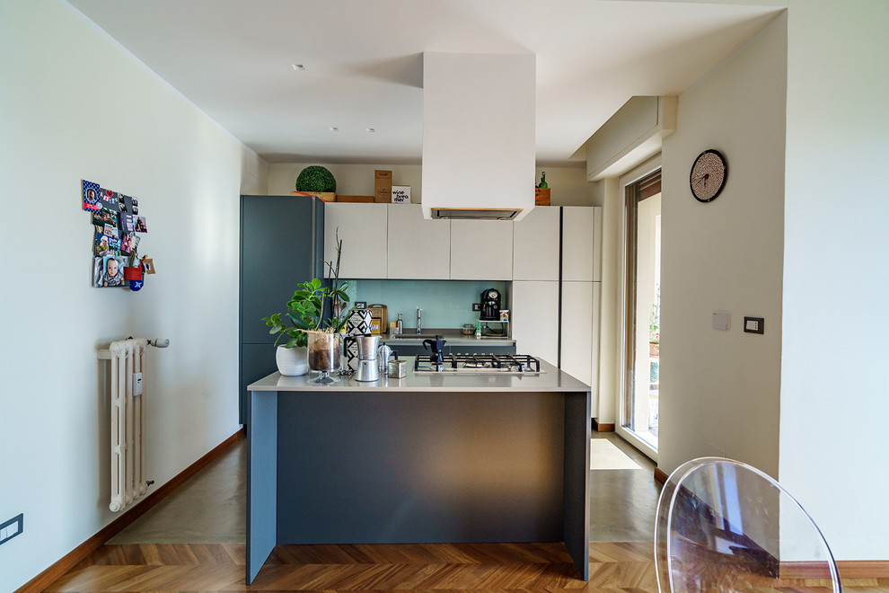 Inspiration for a mid-sized modern single-wall eat-in kitchen in Florence with an undermount sink, flat-panel cabinets, grey cabinets, quartzite benchtops, white splashback, glass sheet splashback, stainless steel appliances, vinyl floors, with island, brown floor and grey benchtop.
