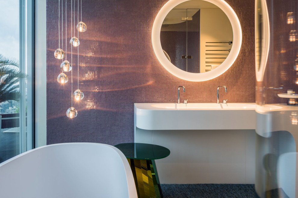 This is an example of a contemporary bathroom in Stuttgart with a freestanding bath and pink tiles.