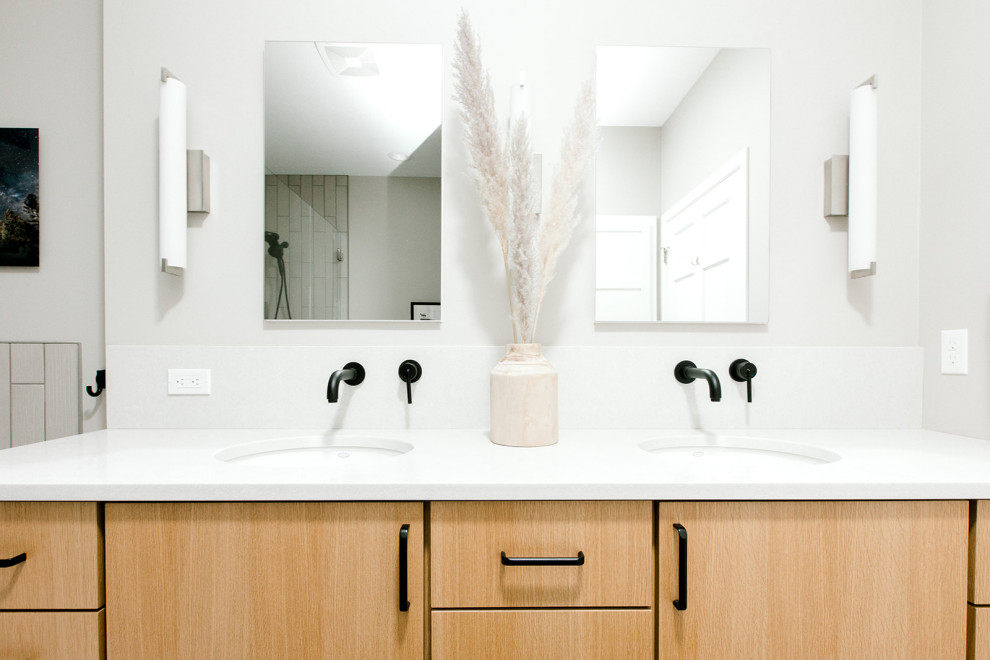 This is an example of a large scandi ensuite bathroom in Other with flat-panel cabinets, light wood cabinets, an alcove bath, beige tiles, porcelain tiles, porcelain flooring, a submerged sink, engineered stone worktops, white floors, a hinged door, grey worktops, a wall niche, double sinks and a built in vanity unit.