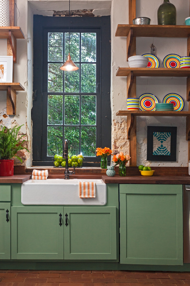 Design ideas for a mid-sized eclectic separate kitchen in Richmond with a farmhouse sink, shaker cabinets, green cabinets, wood benchtops, beige splashback, brick floors and red floor.