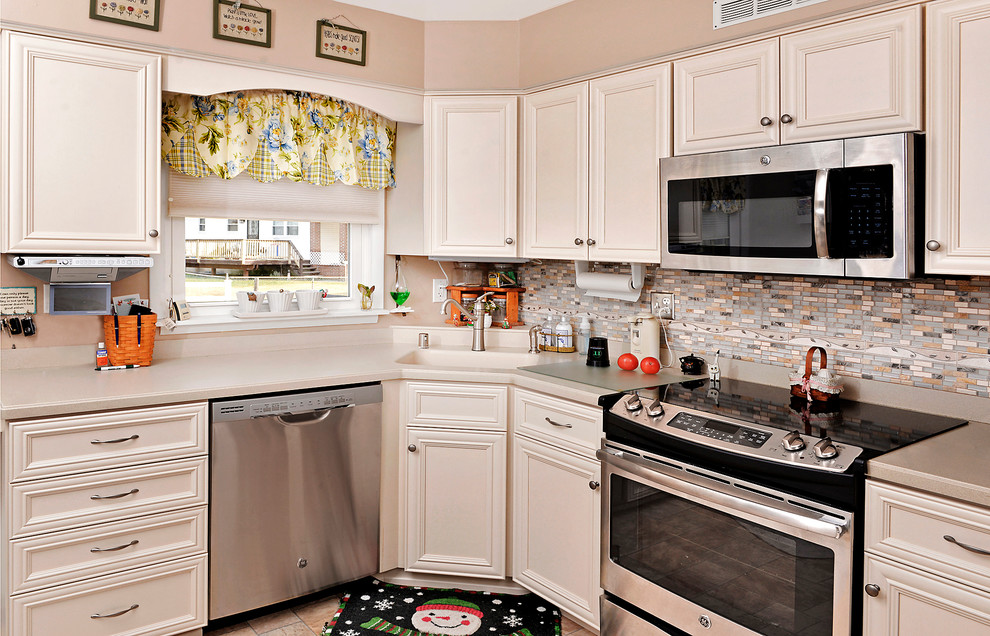 Photo of a mid-sized transitional separate kitchen in Baltimore with recessed-panel cabinets, white cabinets, laminate benchtops, multi-coloured splashback, stainless steel appliances and a peninsula.