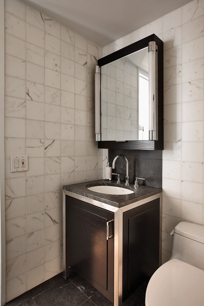 Modern powder room in New York with stone tile and grey benchtops.