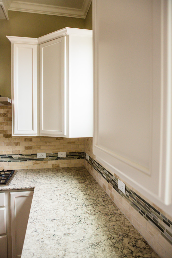Mid-sized transitional l-shaped medium tone wood floor eat-in kitchen photo in Austin with an undermount sink, recessed-panel cabinets, white cabinets, granite countertops, beige backsplash, stone tile backsplash, stainless steel appliances and an island