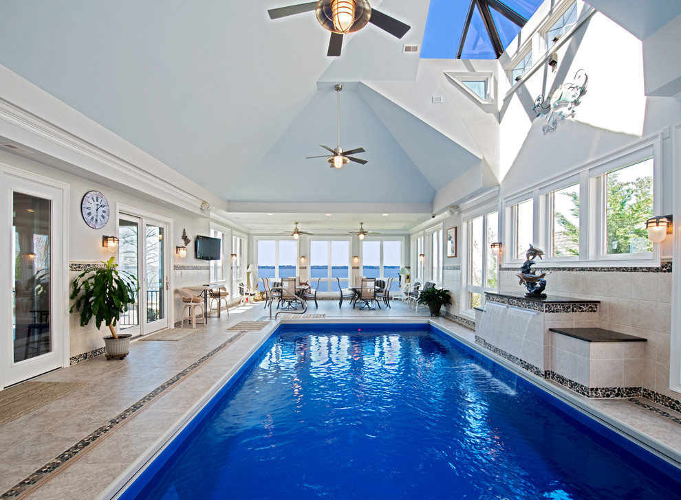 Photo of a large transitional indoor rectangular lap pool in Other with tile and a water feature.