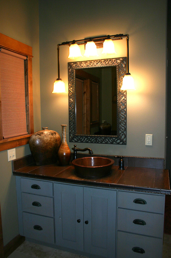 Mountain style metal tile bathroom photo with a wall-mount sink, flat-panel cabinets, gray cabinets and tile countertops