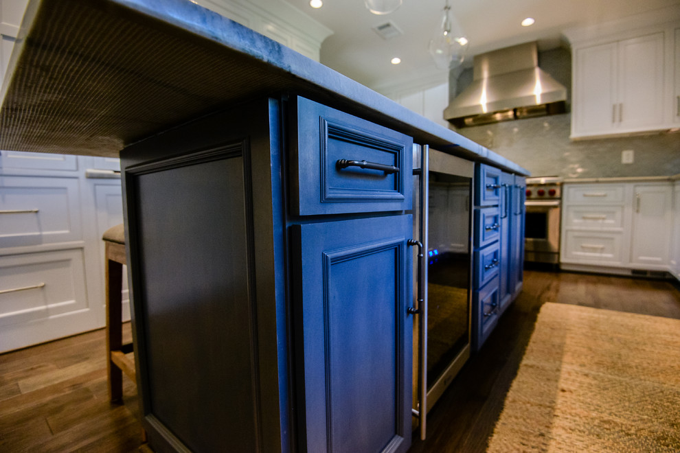 Inspiration for a large transitional u-shaped medium tone wood floor and brown floor eat-in kitchen remodel in DC Metro with a farmhouse sink, recessed-panel cabinets, white cabinets, marble countertops, stainless steel appliances, an island, gray backsplash and porcelain backsplash
