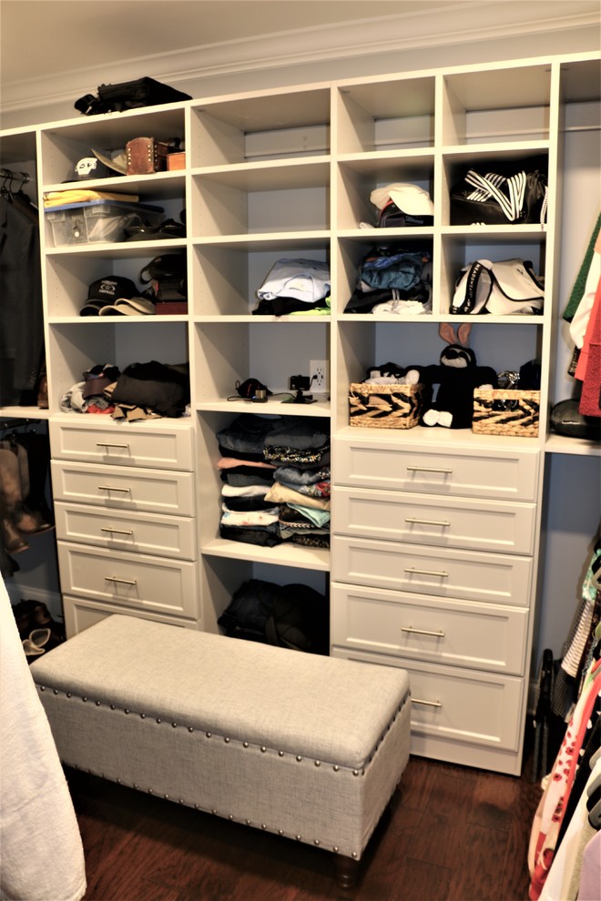 Example of a mid-sized transitional gender-neutral dark wood floor and brown floor walk-in closet design with raised-panel cabinets and white cabinets