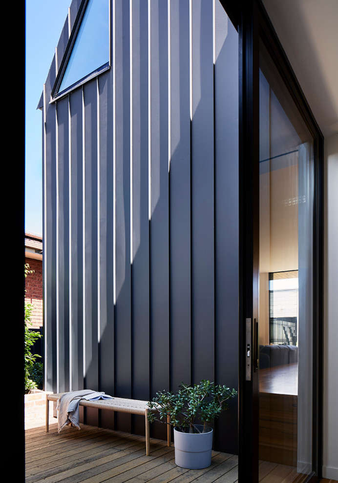 Mid-sized contemporary black two-story house exterior idea in Melbourne with a metal roof and a black roof