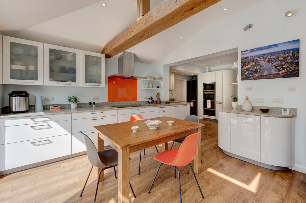 Design ideas for a large contemporary open plan kitchen in London with white cabinets and orange splashback.