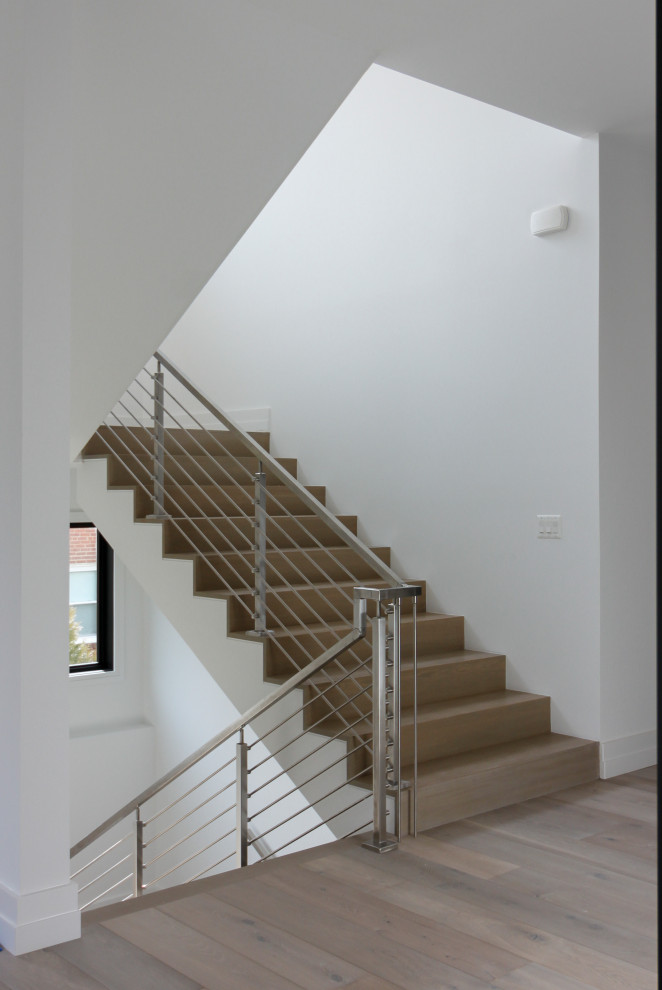 Mid-sized modern wood u-shaped staircase in DC Metro with wood risers and metal railing.