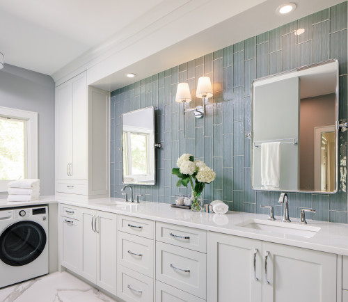Luxury bathroom with white bathroom cabinets, double sinks, quartz countertop, blue tile backsplash, and built-in laundry washer
