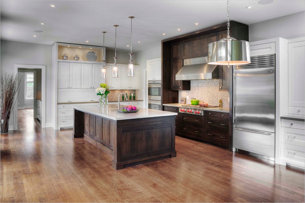 Inspiration for a mid-sized transitional l-shaped eat-in kitchen in Toronto with an undermount sink, shaker cabinets, white cabinets, granite benchtops, metallic splashback, mosaic tile splashback, stainless steel appliances, light hardwood floors and with island.