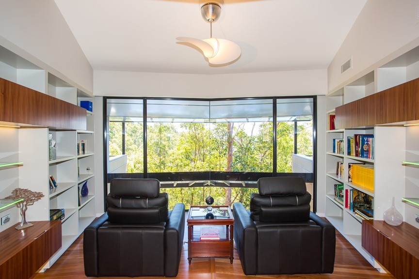 Large modern study room in Brisbane with beige walls and medium hardwood floors.